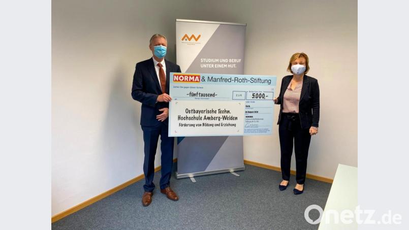 Anton Gleixner, Niederlassungsleiter des Norma-Zweigbetriebs Regenstauf, überreicht an die OTH- Vizepräsidentin Professorin Christiane Hellbach einen Spendenscheck über 5000 Euro. Bild: Märtin/OTH Amberg-Weiden/exb