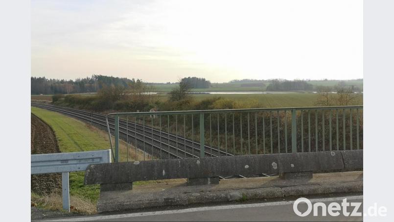 Blick von der Bahnbrücke zwischen Oberteich und Triebendorf: Die Freiflächen-Solaranlage soll in dreieckiger Form auf dem Acker zwischen der Bahnlinie und den Teichen im Hintergrund entstehen. Bild: lnz