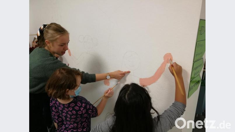Hilfe für die „Kleinen“ durch die „Großen“, den Teilnehmern des P-Seminars bei der Gestaltung der Schulwand. Bild: gsp