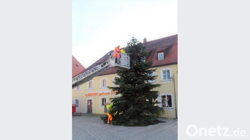 Mit der Drehleiter der Feuerwehr Kemnath brachten die Bauhofmitarbeiter die Beleuchtung am Christbaum in Waldeck an. Bild: hl