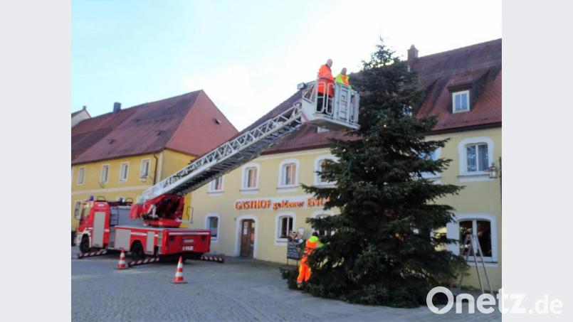 Mit der Drehleiter der Feuerwehr Kemnath brachten die Bauhofmitarbeiter die Beleuchtung am Christbaum in Waldeck an. Bild: hl