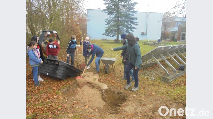 Im Garten der Mittelschule Mitterteich soll ein Feuchtbiotop entstehen. Unter fachkundiger Anleitung setzten die am Projekt beteiligten Jugendlichen eine Teichwanne und gestalteten die Uferzone. Bild: Mittelschule Mitterteich/exb