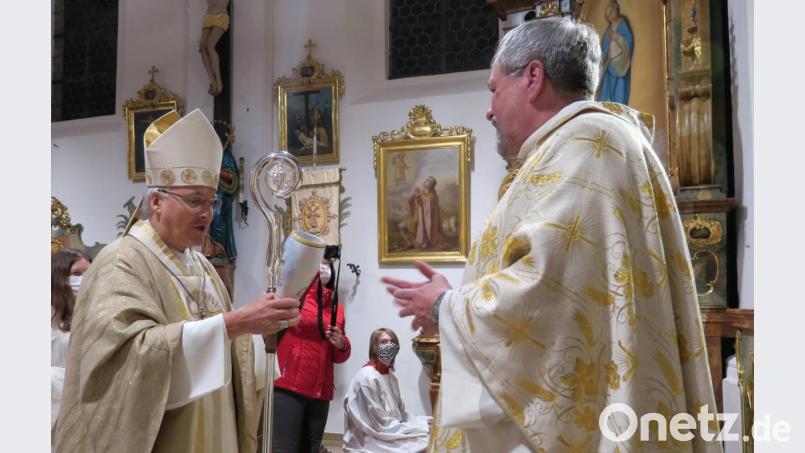 Pfarrer Markus Ertl (rechts) überreichte Bischof Rudolf Voderholzer (links) einen Weizenkrug mit dem Bildmotiv der Expositurkirche St. Vitus in Neunaigen. Der Oberhirte bedankte sich für das Geschenk und die Einladung zur Segnung der renovierten Kirche. Bild: Hirsch