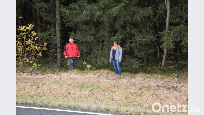 Hans-Peter Reil (links) &quot;übergibt&quot; den Waldthurner Christbaumverkauf an die Vorsitzende der Trachtenkapelle Waldthurn, Birgit Bocka (rechts). Wo ist dieses Bild entstanden? Wer das Rätsel löst, hat die Chance auf zwei große Gewinne, die die Musiker ausloben. EIn Tipp dazu in Reimform: Das Foto wurde auf dem Weg zum heiligen Berg gemacht. Vielen Wanderern hat er als Streckenstart schon schöne Stunden gebracht. Bild: fla