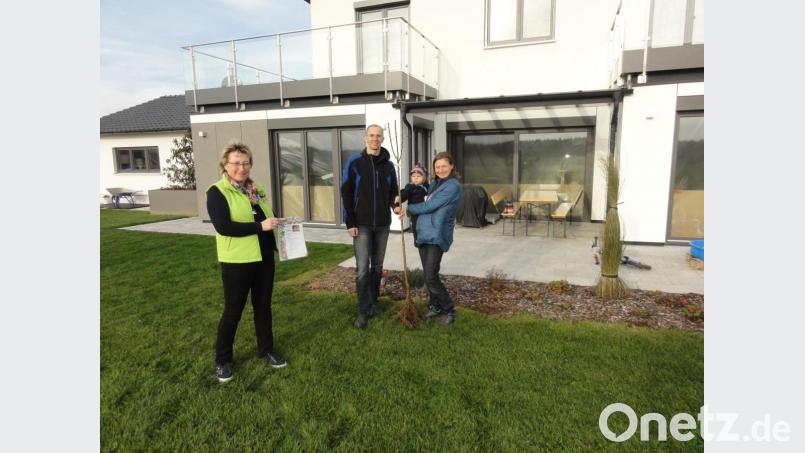 Thomas und Andrea Arnold mit Elias freuen sich über den Apfelbaum des Obst- und Gartenbauvereins, den zweite Vorsitzende Christine Walter (links) der jungen Familie überreichte. Bild: jhö
