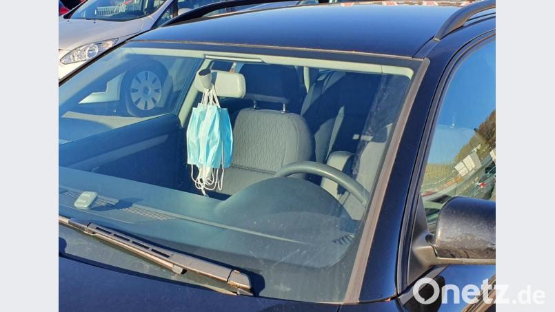 Am Rückspiegel eines Autos hängen mehrere Mund-Nase-Masken. Symbolbild: Hösamer
