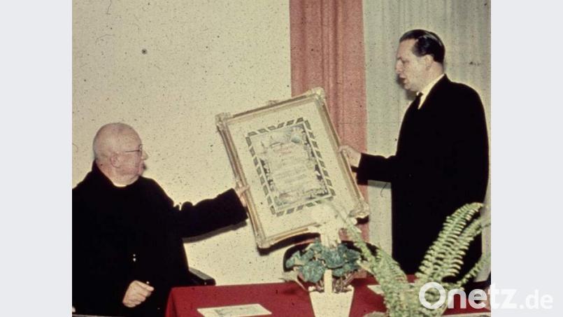 Im Rahmen einer Sondersitzung überreichte Bürgermeister Willi Bösl (r.) am 14. Dezember 1958 Bischöflich Geistlichem Rat Friedrich Zeitler (l.), der sein 25-jähriges Ortsjubiläum feierte, die Ehrenbürger-Urkunde. Anlass war Pfarrer Zeitlers 25-jähriges Ortsjubiläum. Bild: u