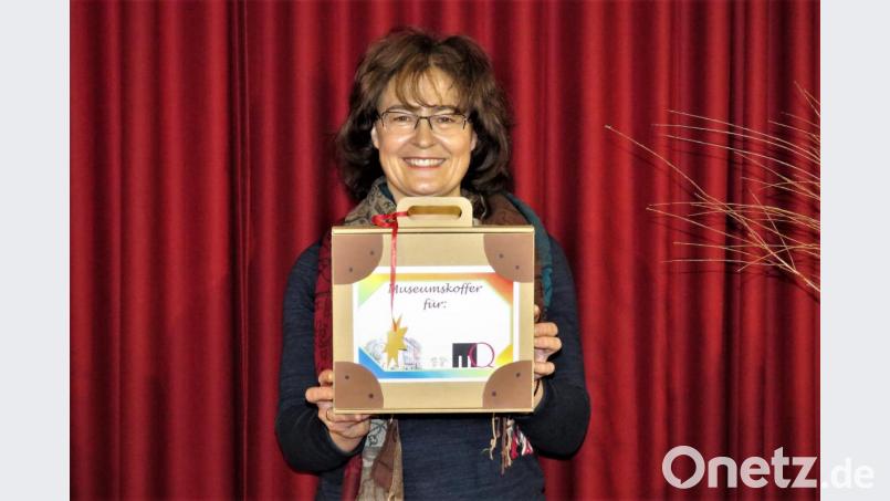 Erika Rahm zeigt das Köfferchen, das Kindern mit viel Inhalt zum Basteln und Spielen während der Weihnachtszeit Spaß und ein wenig Museum nach Hause bringen soll. Bild: ubb