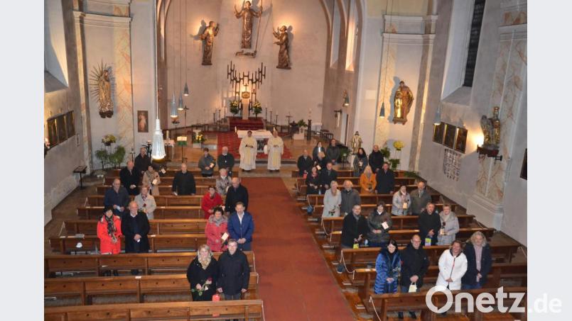20 Paare feiern Ehejubiläum in einem Gottesdienst in der Pfarrkirche. Pfarrer Udo Klösel (Mitte links) segnet sie. Bild: gi