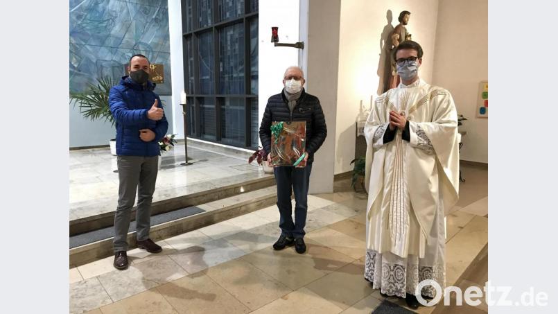 Pfarrer Thomas Kopp (rechts) und Sprecher des Pfarrgemeinderats Ralph Bauer (links) verabschieden Karl Voit und bedankten sich für den aktiven Dienst in der katholischen Pfarrgemeinde. Bild: adj