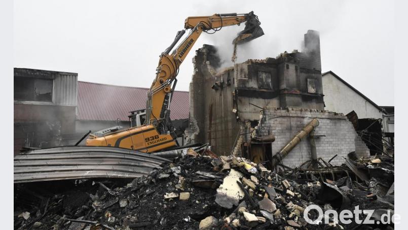 Ein Bagger schaufelt die Holzspäne aus dem meterhohen Gebäude. Sie können unter Umständen noch tagelang glimmen. Bild: Petra Hartl