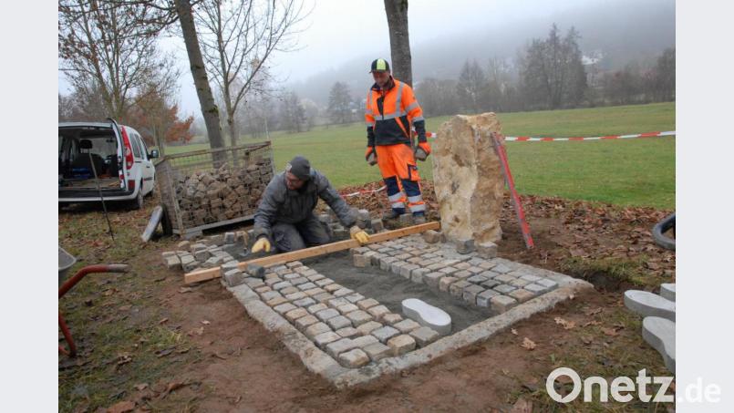 Marktrat Markus Mehringer und Gemeindearbeiter Daniel Wolfsteiner errichten die Gedenkstätte. Bild: pop
