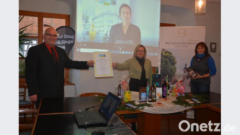 Die Marktgemeinde Bad Neualbenreuth bekam jetzt den Titel „Fairtrade-Gemeinde“ verliehen. Darüber freuen sich (von links) Bürgermeister Klaus Meyer, Ursula Stingl (Gäste-Info) und Angela Frank, Sprecherin der Fairtrade-Steuerungsgruppe. Im Hintergrund Lisa Herrmann von Fairtrade-Town bei ihrer Video-Grußbotschaft. Bild: jr