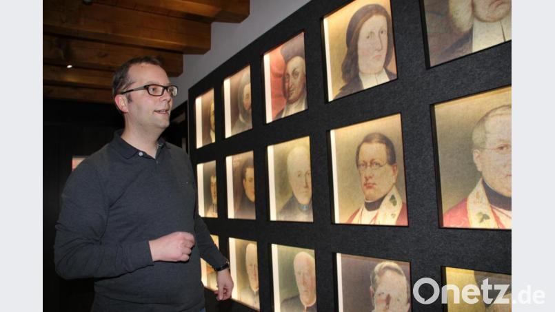 In moderner und sehr ansprechender Form hat die Ahnengalerie der Stadtpfarrer von St. Martin Eingang in das neue Pfarrhaus gefunden, die bereits im Eingangsbereich die Besucher begrüßen. Stadtpfarrer Thomas Helm freut sich über die gelungene Variante der Ahnengalerie. Bild: ads