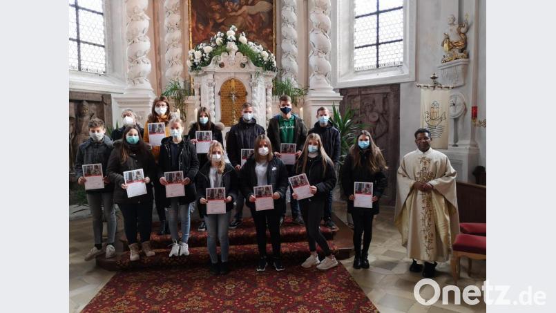 Pfarrer Georg Parampilthadathil (rechts) verabschiedete insgesamt 15 Ministranten und danke ihnen für den jahrelangen treuen Dienst mit einer Urkunde und einem Präsent. Bild: hir