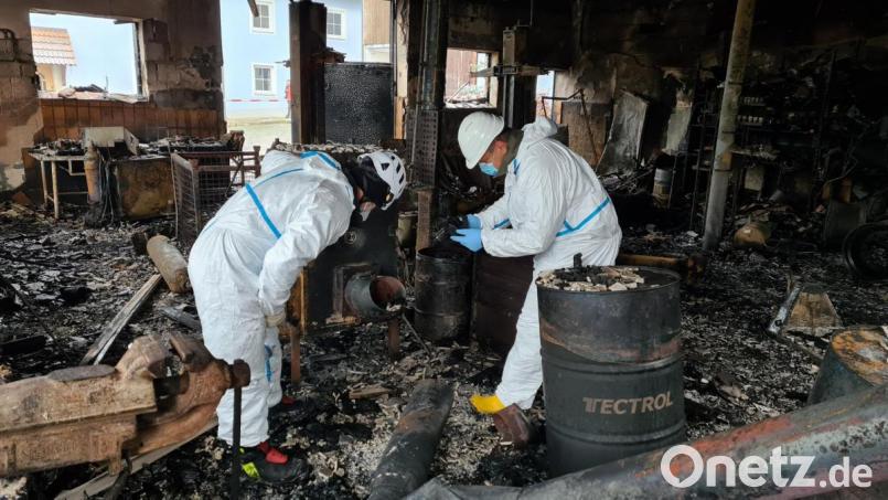 Brandfahnder der Polizei sind am Tag nach dem Großbrand in Erbendorf auf der Suche nach der Ursache des Feuers in einer landwirtschaftlichen Halle. Bild: rw
