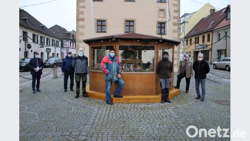 Die Schnitzergemeinschaft hat die traditionelle Weihnachtskrippe aufgestellt. Bürgermeister Edgar Knobloch (links) freut sich über die Verzierung des Marktplatzes. Bild: sne