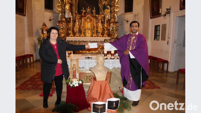 300 Euro überreichte Carolin Knott am Kolpinggedenktag in der Pfarrkirche an Pfarrer Pater Anish George für das Projekt „Dach über dem Kopf“. Bild: soj