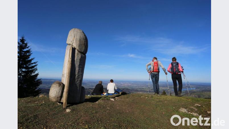Wanderer genießen neben der zwei Meter hohen Penis-Skulptur aus Holz auf dem Grat des Grünten den Ausblick. Bild: Karl-Josef Hildenbrand