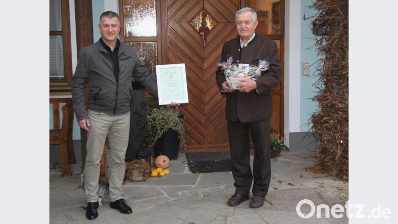 Glückwünsche zum 80. Geburtstag für Johann Lindner (rechts) vom Bürgermeister und Vorsitzenden des Männergesangsvereins Dietmar Schaller bei der Überreichung der Urkunde zum Ehrenvorstand Bild: fsb