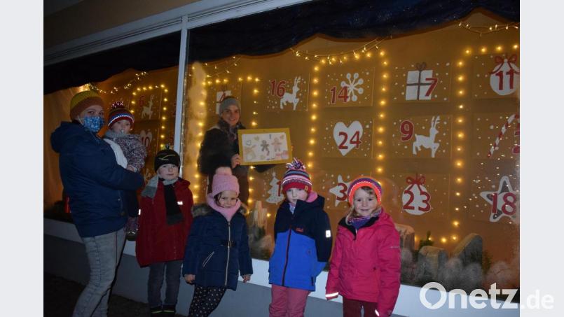 Einige Kinder rund um Anna-Lena Rupprecht (links) und Anna Stangl (im Schaufenster) freuen sich schon auf die Enthüllung ihres Bildes im großen Adventskalender. Bild: szl