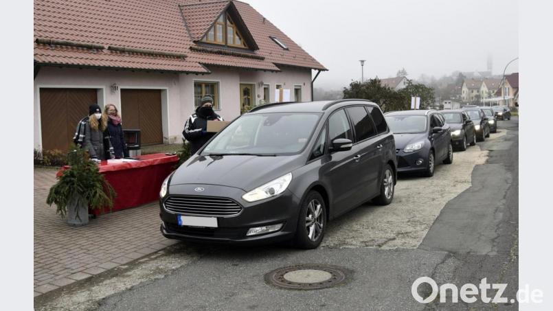 Lange Schlangen bilden sich beim „Drive in“ am Mühlenweg. Vorsitzender Michael Sporrer überreicht an die Autofahrer den „Adventszauber zum Mitnehmen“. Bild: lep