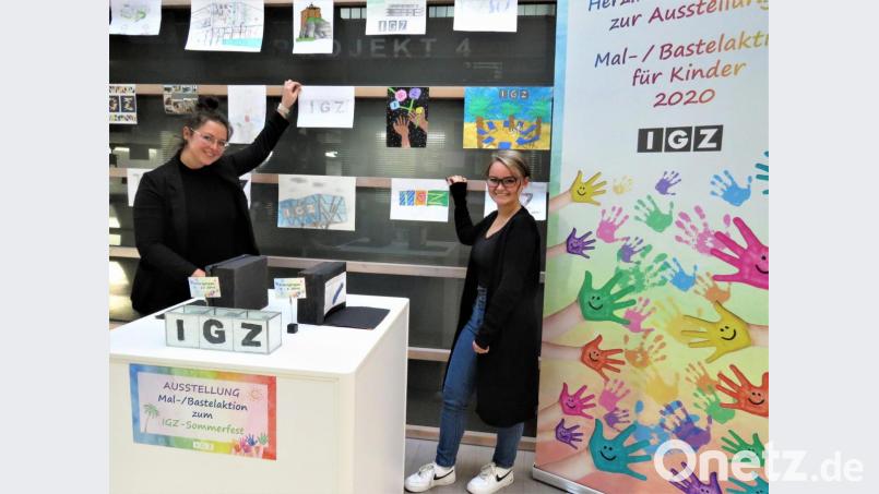 Charlotte Zintl und Marleen Stock haben viel Spaß beim Aufhängen der Kinderbilder im Foyer des IGZ-Hauptgebäudes. Bild: ubb