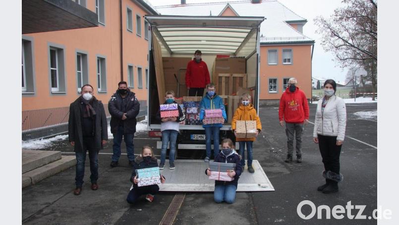 An der Aktion „Geschenk mit Herz“ beteiligt sich die Grundschule seit zehn Jahren. Der Spendenaufruf war auch heuer erfolgreich. Darüber freute sich Rektorin Inge Dick (rechts). Walter und Petra Reim (in den roten Sweat-Shirts) holten die Päckchen am Mittwoch ab. Beim Aufladen halfen ihnen einige Schüler und (von links) Bernd Zwerenz sowie Oliver Zrenner (Mitglied des Elternbeirates). Bild: wro