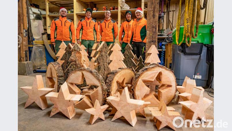 Mit Spaß bei der Arbeit: Forstwirtschaftsmeister und Auszubildende des Forstbetriebs Fichtelberg präsentieren den rustikalen Schmuck aus der Weihnachtswerkstatt. Bild: Martin Hertel/exb