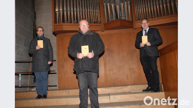 Stadtpfarrer Thomas Helm, der Vorsitzende des Vereins „Projekt Orgel St. Martin Amberg,“ Franz Meier, und Regionalkantor Bernhard Müllers (von links) freuen sich über das Buch „Das Leben ist erschienen“ mit Liedtexten aus der Feder des ehemaligen Stadtpfarrers von St. Martin, Monsignore Franz Meiler. Bild: ads