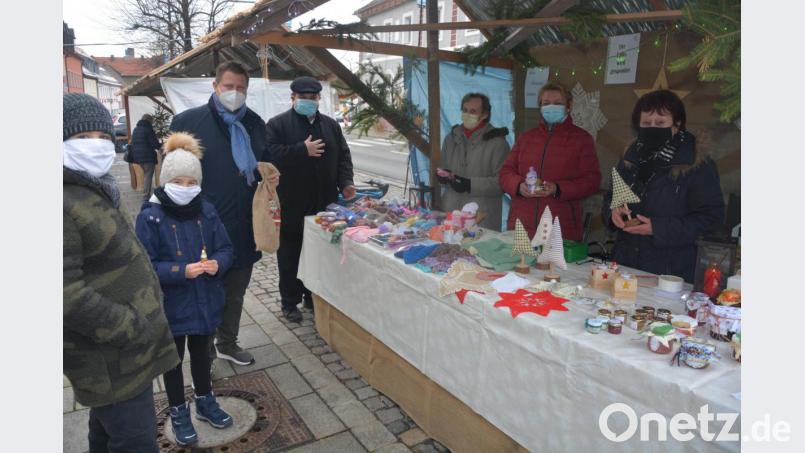 Bürgermeister Stefan Grillmeier (3. von links) und Kaplan Daniel Schmid (4. von links) machten sich am Samstagnachmittag auf eine kurze Tour durch die Innenstadt und die Verkaufsbuden. Hier besuchten sie den Stand des Katholischen Frauenbundes. Bild: jr