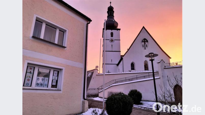 Wer zur richtigen Zeit kommt, kann den Adventskalender der Bücherei und die Kirche im herrlichen Farbenspiel des Himmels erleben. Bild: rpp