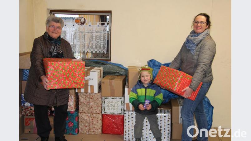 Die Resonanz auf die Weihnachtspaketaktion der Rumänienhilfe der Katholischen Kirchenstiftung St. Georg ist groß. Bereits jetzt wurden 400 Pakete abgeliefert. Erna Hauer (links) hat noch bis zum Abgabeschluss am 12.12. alle Hände voll zu tun, um die Hilfspakete wie dieses von Susanne Kraus (rechts) und Söhnchen Leopold einstweilen zwischen zu lagern. Bild: prh