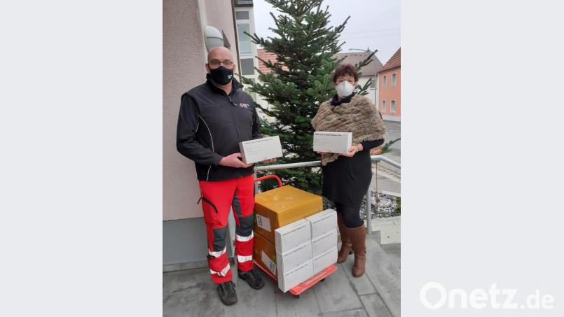 Michael Schmid vom BRK-Kreisverband Amberg-Sulzbach übergibt die Schnelltests an Heimleiterin Astrid Geitner. Bild: exb