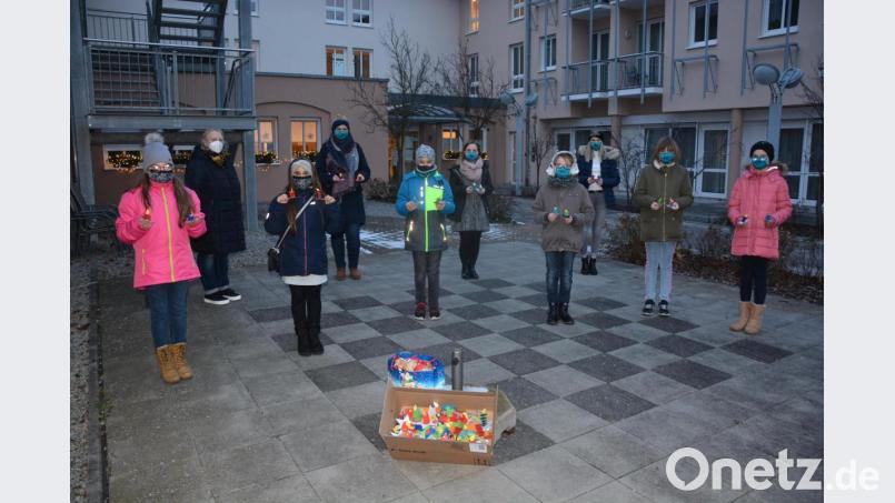 BRK-Jugendleiterin Julia Spandel (Vierte von links) überreichte gemeinsam mit einigen Kindern und Jugendlichen 110 selbstgebastelte Kerzen an Jutta Ernst (Zweite von links) vom Phönix-Seniorenheim. Allen Senioren des Hauses wurde damit eine kleine Nikolaus-Überraschung bereitet. Bild: jr