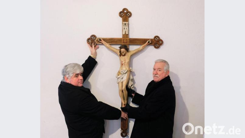 Oberstudiendirektor a.D. Reinhold Knollmüller (rechts) übergibt ein im Familieneigentum befindliches wertvolles Kruzifix mit wechselvoller Geschichte an Stadtpfarrer Thomas Jeschner. Bild: do