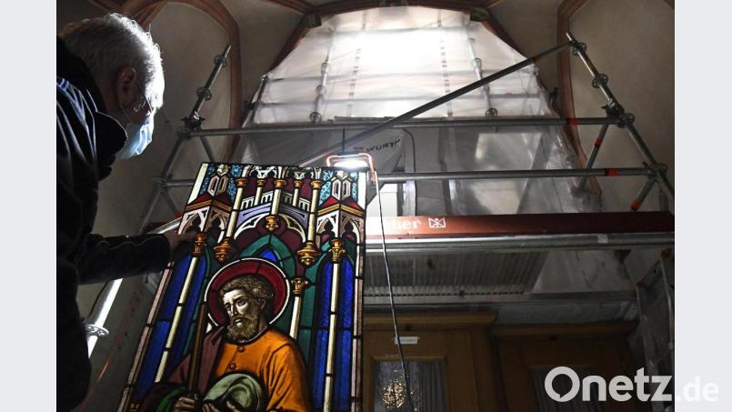 Hier ist das Fenster schon ausgebaut. Ein Innengerüst verschafft den Experten Zugriff auf die wertvollen Glas-Kunstwerke, zum Beispiel mit einer Josef-Darstellung. Im Hintergrund zu sehen sind die Folien. Diese und die dahinter liegenden Schichtholzplatten mit Plexiglaseinsätzen sollen vor allem Regen und Schnee abhalten, so lang die Fenster in Paderborn restauriert werden. Bild: Petra Hartl