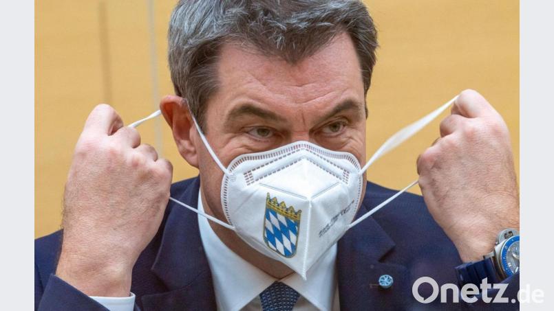 Markus Söder (CSU), Ministerpräsident von Bayern, nimmt während der Sitzung des bayerischen Landtags seine Mund-Nasen-Bedeckung ab. Bild: Peter Kneffel/dpa