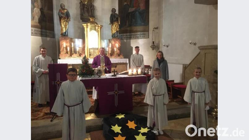 Pfarrer Theo Schmucker (am Altar) und Gemeindereferentin Patrizia Szörenyi begrüßten drei neue Ministranten (vorne). Bild: Julia Hirsch/exb
