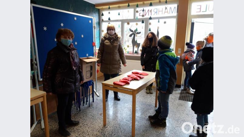 Edith Bracke, Rektorin der Grundschule (rechts), sowie Brigitte Hoffmann und Rosa Schöner von der Pfarrei Mähring teilen an die Schüler der Grundschule Mähring, die beim Nikolausgottesdienst nicht dabei sein konnten, kleine Nikolaussäckchen aus. Bild: Rosa Schöner/Pfarrei Mähring/exb