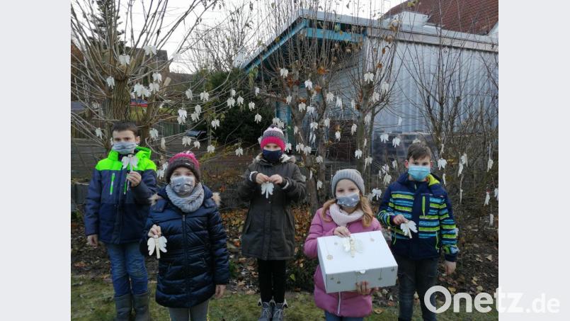 Einige an der Aktion beteiligte Kinder vor einem Strauch mit den gebastelten Engeln: (von links) Elias, Anna, Sofie, Sarah und Simon. Bild: Stefanie Riedl/exb