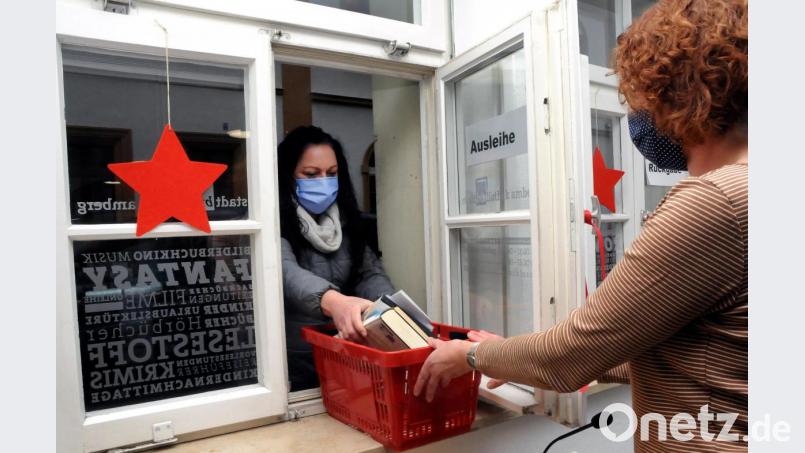 Ab sofort ist in der Stadtbibliothek die Ausleihe durchs Fenster möglich. Kathrin Rieger (links) war am Mittwoch die Erste, die diesen Service nutzte. Bibliotheks-Mitarbeiterin Gabriele Gander reichte ihr durchs Fenster ein Körbchen mit den vorbestellten Büchern. Bild: Stephan Huber