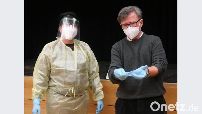 Zentrumsleiter Dr. Richard Wagner (rechts) händigte den Testern die Schutzkleidung aus und zeigte ihnen, wie sie sich ihrer nach dem Gebrauch wieder entledigen können, ohne sich selbst zu gefährden. Bild: rhi