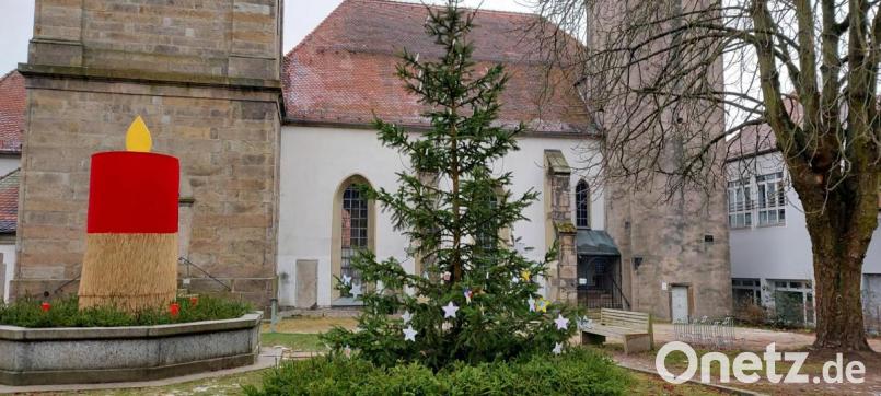 Der evangelische Pfarrhof wurde bereits auf die anstehenden Freiluft-Gottesdienste vorbereitet. Beim Kriegerdenkmal bei der Bartholomäus-Kirche steht eine überdimensionale Kerze. Bild: abi