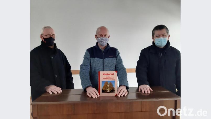 Über eine literarische und historische Sternstunde freuen sich (von links): Kirchenpfleger Sigmund Geisler, Autor Josef Wiche und Pfarrer Ferdinand Weinberger. Der Bucheinband zeigt den erhaltenen Turm des einstigen Dorfkirchleins. Genau an diesem Standort erhoben sich während des Mittelalters die Kirchen im Zentrum von Mehlmeisel. Bild: gis