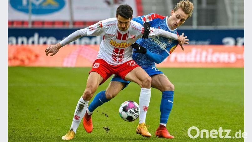 Sebastian Stolze (vorne) vom SSV Jahn Regensburg und Ex-Teamkollege Joshua Mees (Holstein Kiel) im Kampf um den Ball. Bild: Armin Weigel/dpa