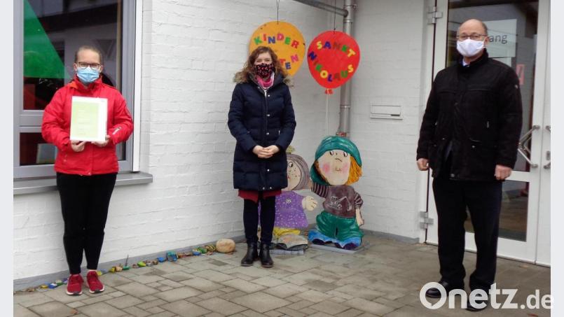 Kindergartenleiterin Theresa Koch (links) durfte aus den Händen von Christina Apel die Urkunde für erfolgreiche Teilnahme am Coaching für Kitaverpflegung entgegennehmen. Pfarrer Heribert Englhardt freute sich über das tolle Engagement seines Kindergartenteams zum Wohle der Kinder. Bild: wlr