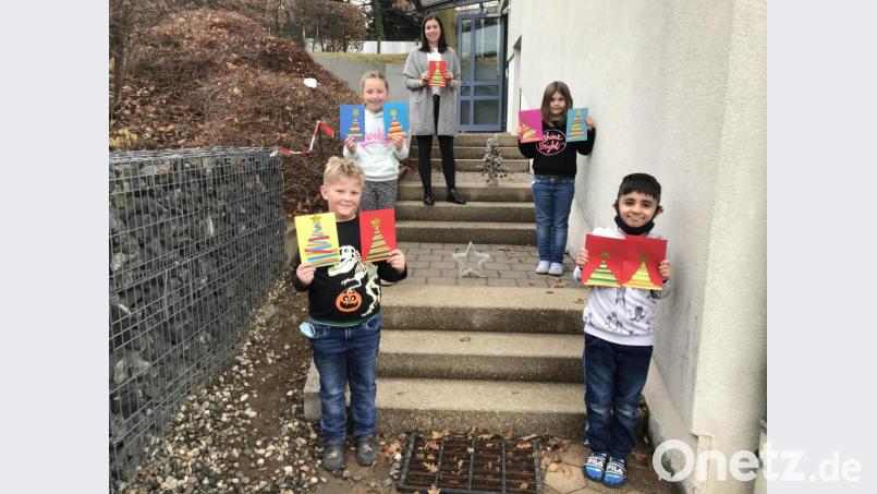 Stellvertretend für ihre Klasse präsentieren diese Schüler ihre selbstgebastelten Karten. Sie werden von Lehrerin Christina Decker im Alten- und Pflegeheim abgegeben und an die Bewohner verteilt. Bild: wel