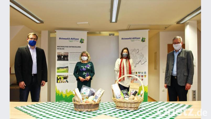 Steinwald-Allianz Geschäftsführer Martin Schmid, die Projektmanagerinnen Eva Gibhardt und Elisabeth Waldeck sowie Bürgermeister Johannes Reger, Vorsitzender der Steinwald-Allianz (von links) präsentieren den Geschenkkorb. . Bild: njn