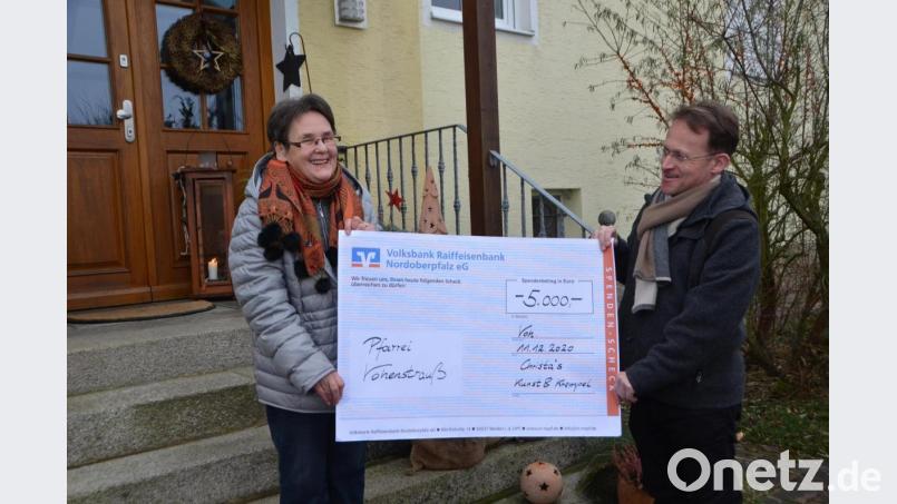 Christa Wildenauer überreicht Dekan Alexander Hösl einen mit 5000 Euro dotierten Scheck. Bild: dob
